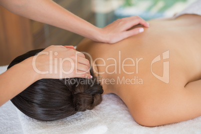 Brunette enjoying a massage lying on towel