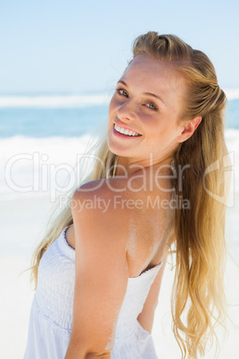 Pretty carefree blonde smiling at camera on the beach