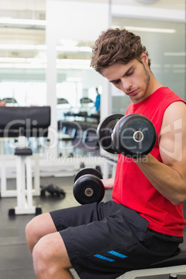 Fit man lifting heavy black dumbbells