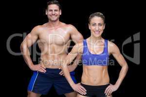 Crossfit couple smiling at camera with hands on hips