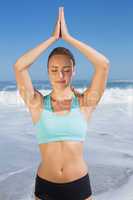 Fit woman meditating on the beach