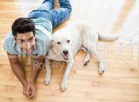 Attractive man lying on floor with his labrador