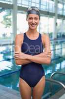 Pretty swimmer smiling at camera by the pool