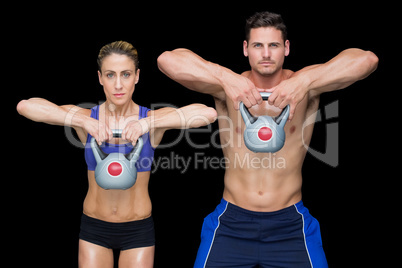 Crossfit couple posing with kettlebells