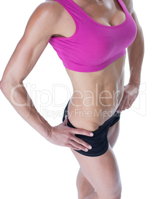 Female bodybuilder posing with hands on hips mid section