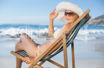 Pretty woman relaxing in deck chair on the beach