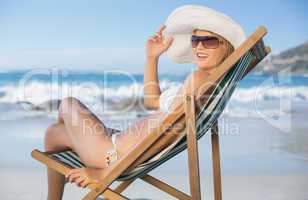 Pretty woman relaxing in deck chair on the beach