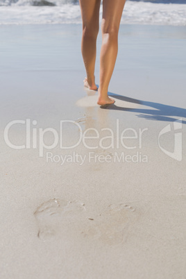 Womans legs standing on the sand