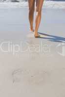 Womans legs standing on the sand