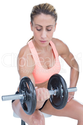 Strong woman doing bicep curl with large dumbbell