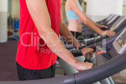 Man and woman standing on treadmills