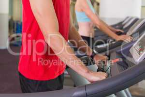 Man and woman standing on treadmills