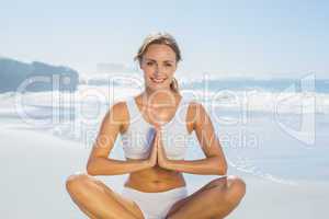 Gorgeous blonde in lotus pose by the sea