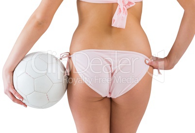 Pretty girl in bikini holding football