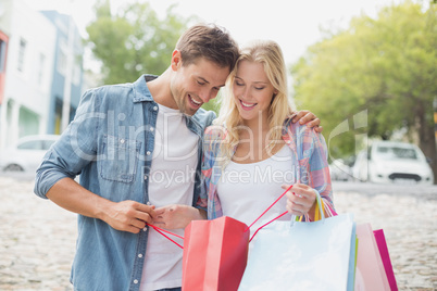 Hip young couple looking at their shopping bags