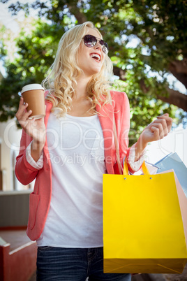 Pretty blonde holding shopping bags and coffee cup