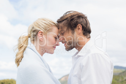 Cute smiling couple standing outside facing each other