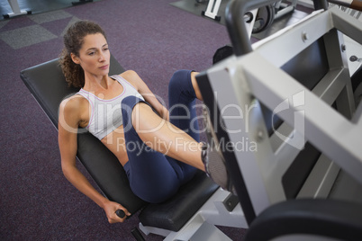 Fit woman using weights machine for legs