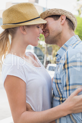 Young hip couple hugging about to kiss