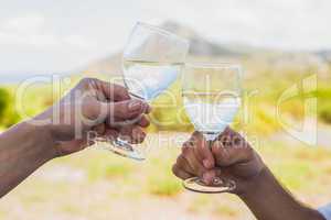 Couple clinking wine glasses outside