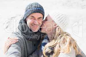 Attractive couple on the beach in warm clothing