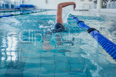 Fit swimmer doing the front stroke in the swimming pool