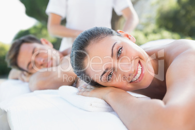 Attractive couple enjoying couples massage poolside