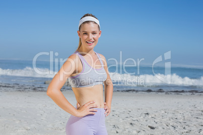 Sporty smiling blonde standing on the beach