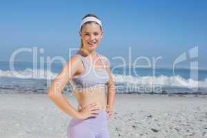 Sporty smiling blonde standing on the beach