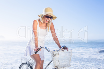 Gorgeous happy blonde on a bike ride at the beach