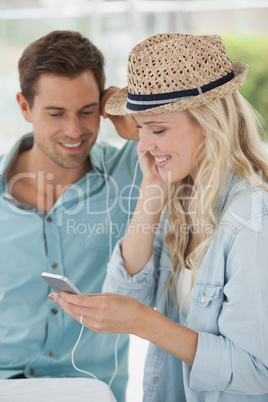 Cute couple listening to music together in cafe