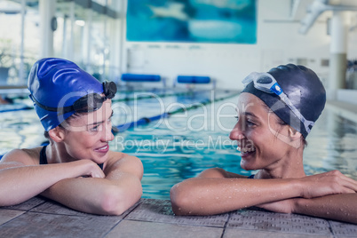 Female swimmers smiling at each other in the swimming pool