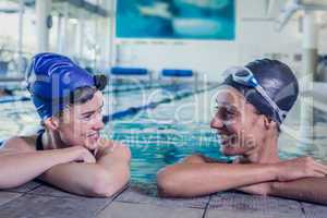 Female swimmers smiling at each other in the swimming pool