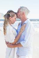 Man kissing his partner on the forehead at the beach