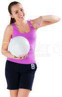 Fit brunette holding ball pointing at it