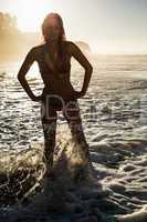 Happy blonde standing in the sea posing in bikini