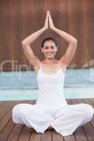 Peaceful happy woman in white sitting in lotus pose