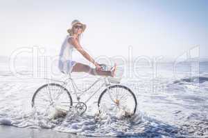 Gorgeous happy blonde on a bike ride at the beach