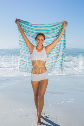 Gorgeous fit blonde standing by the sea with scarf