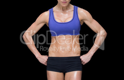 Strong woman posing in sports bra and shorts