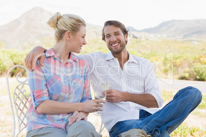 Cute couple sitting in the garden enjoying wine together