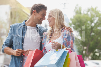 Hip young couple holding shopping bags