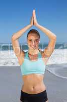 Fit woman meditating on the beach