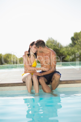 Gorgeous couple sitting poolside on holidays