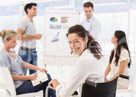 Casual businesswoman in wheelchair smiling at camera during meet