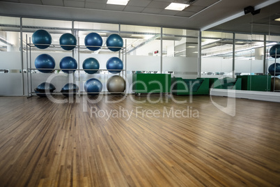 Large empty fitness studio with shelf of exercise balls
