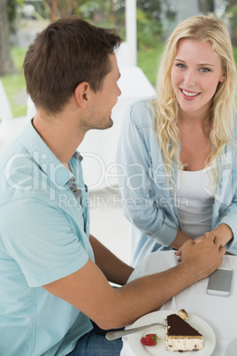 Hip young smiling couple having desert together