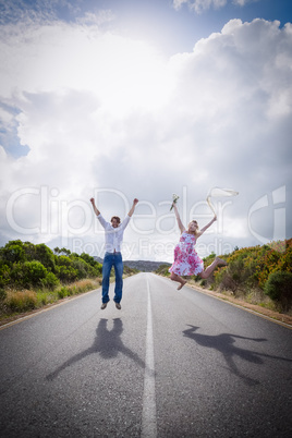 Excited couple jumping on the road