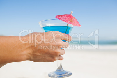Woman sitting in deck chair with a cocktail at the beach Woman sitting in deck chair with a cocktail at the beach