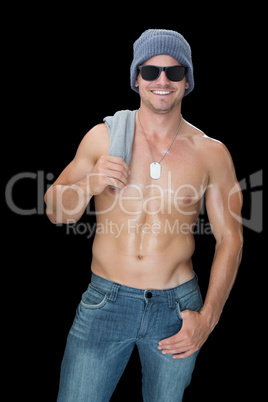 Muscular man posing in blue jeans hat and sunglasses